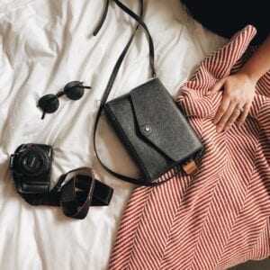 Black purse with accessories on a blanket